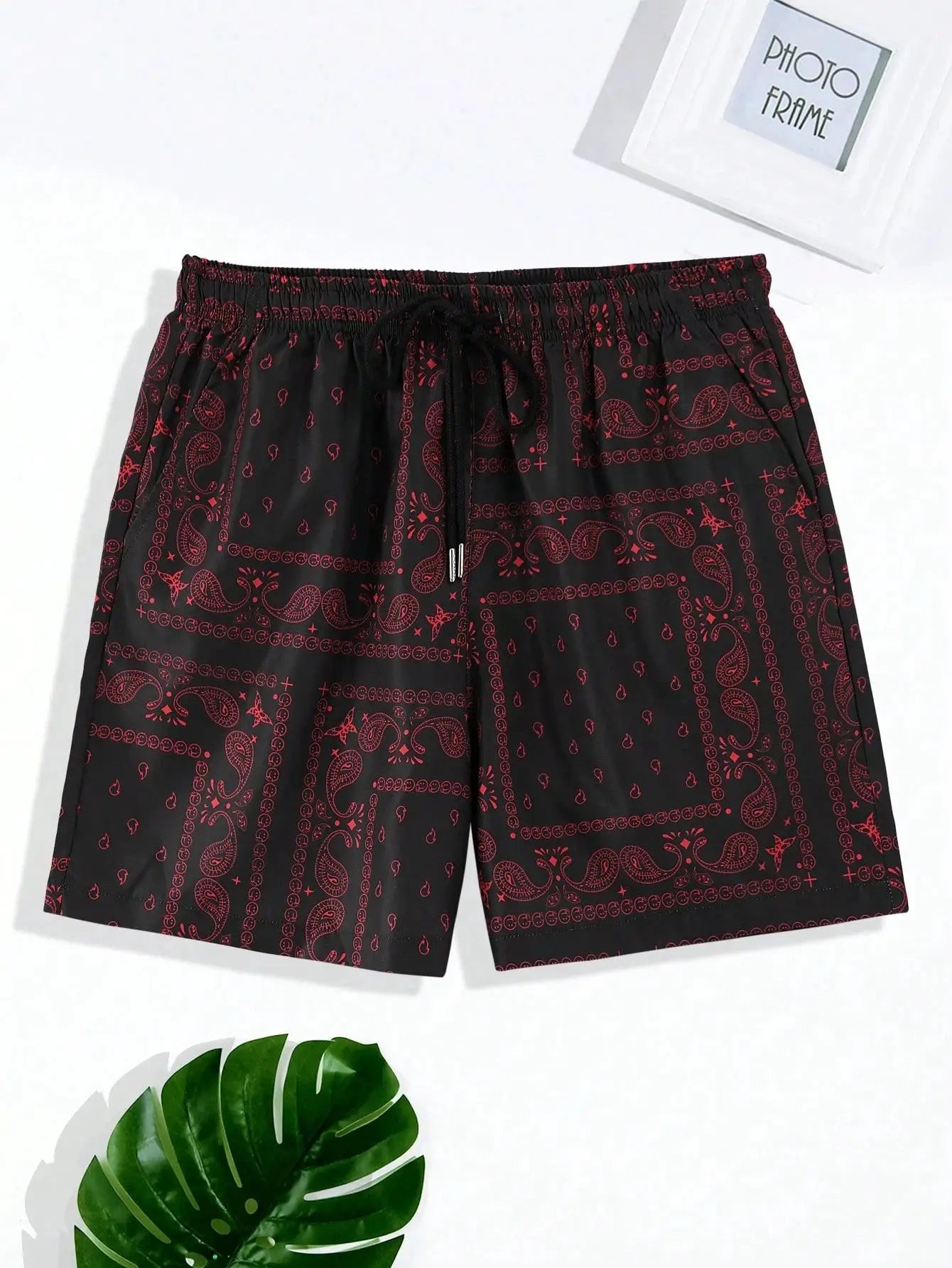 Men's bandana-patterned black beach shorts with red paisley print and drawstring waist