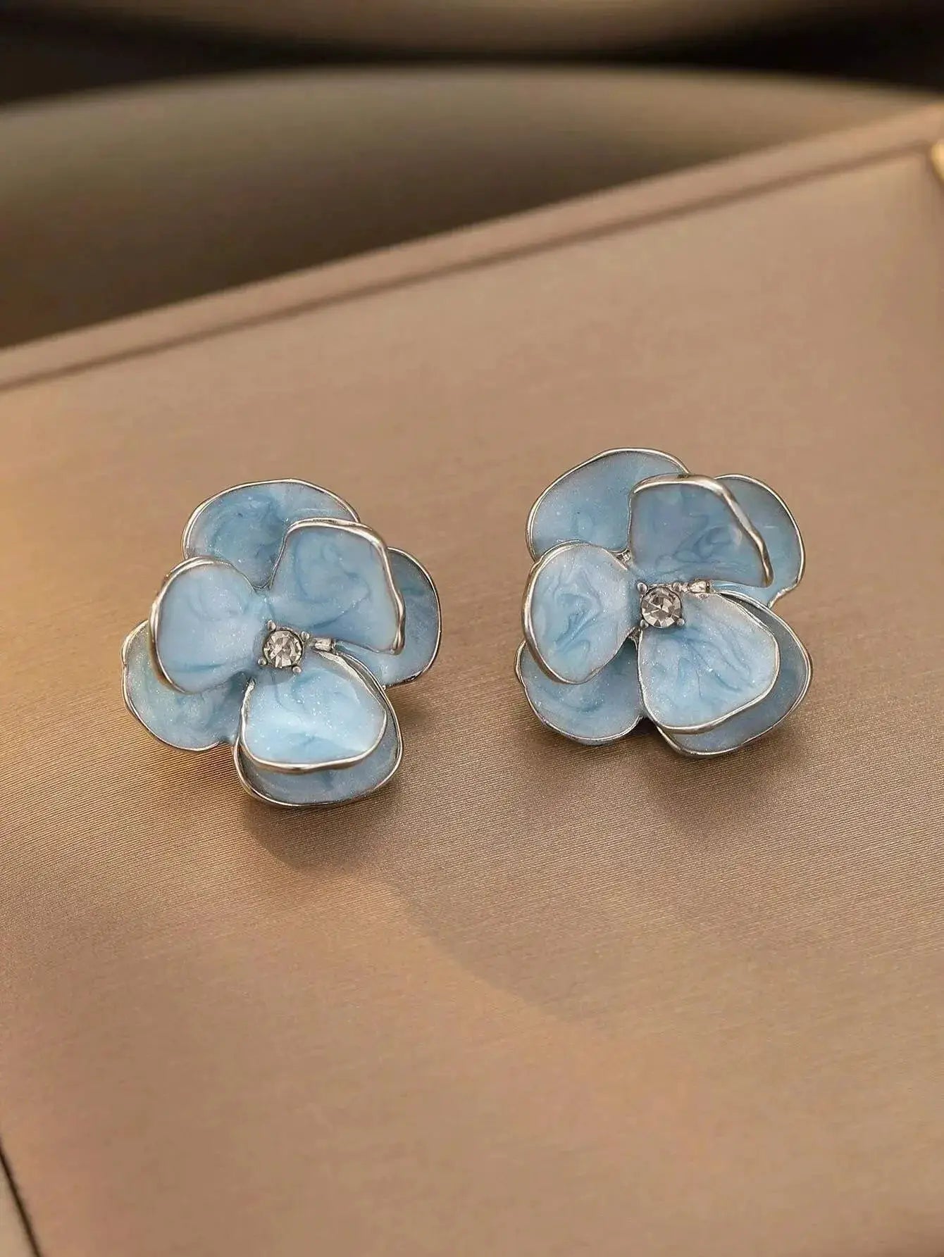 Earrings: pair of blue enamel flower earrings with silver-tone edges and crystal centers