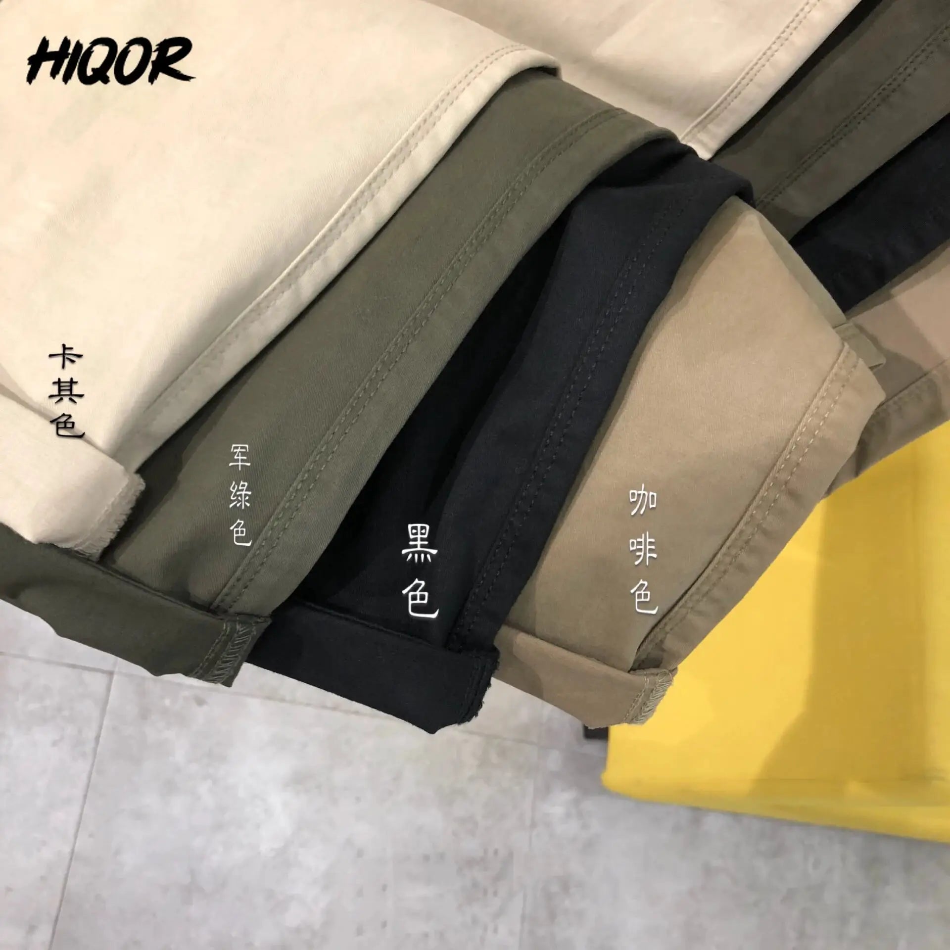 HIQOR men's cotton elastic pants in assorted colors, folded stack with visible stitching