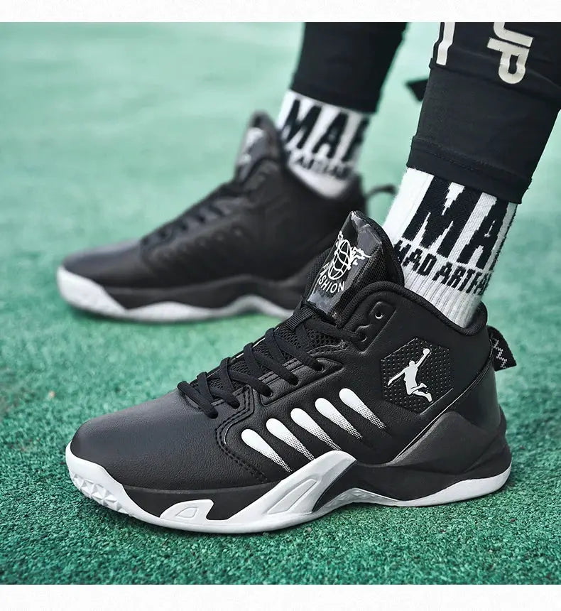 Pair of men's black sneakers with white sole on green turf, featuring side logo patch and white laces