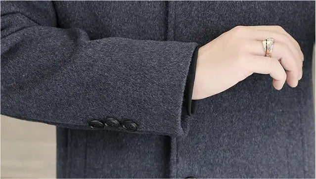 Men's long wool coat in dark gray with removable thickened down inner liner, close-up on sleeve and hand