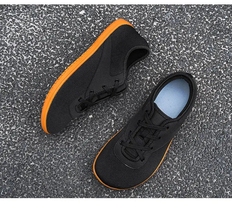 Simples Market men's barefoot trail running shoes, black uppers with orange soles, wide width (two shoes shown)