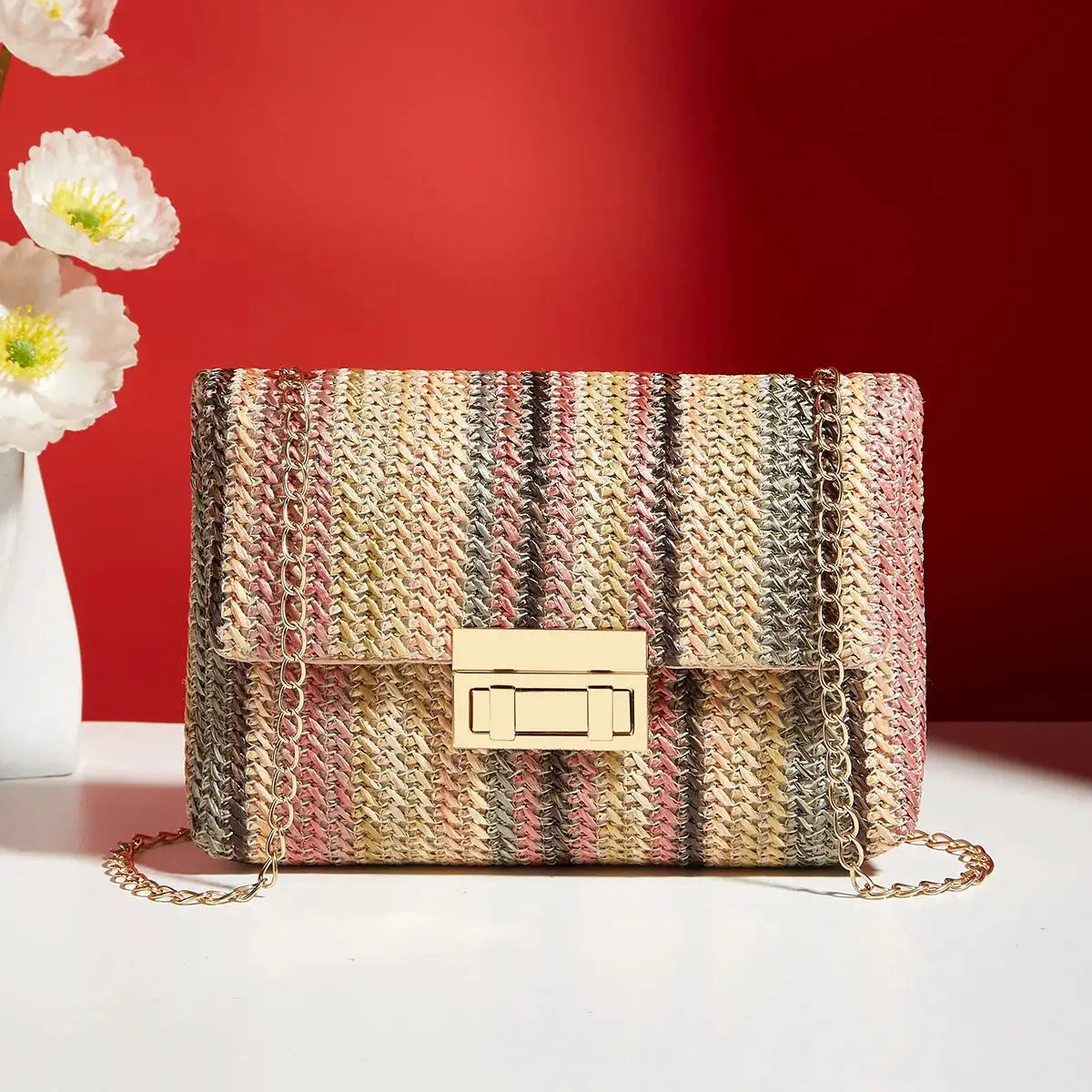 Crossbody bag for women by Simples Market; woven pastel striped straw with a gold chain strap and gold clasp