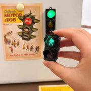 Traffic light magnetic refrigerator sticker; black three-light unit with green pedestrian signal, held by hand