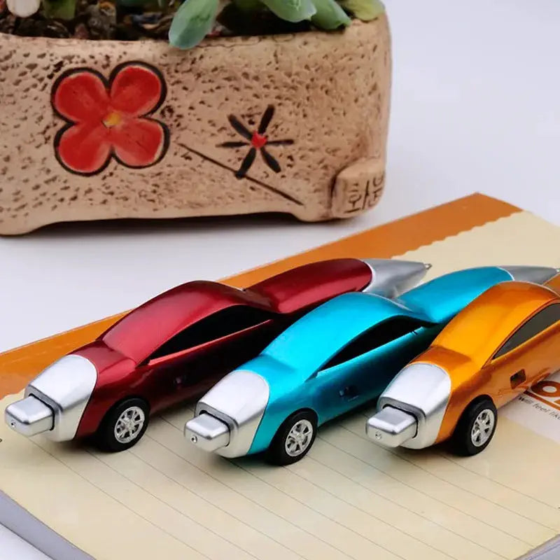 Three candy-color car-shaped ballpoint pens in red, blue, and orange