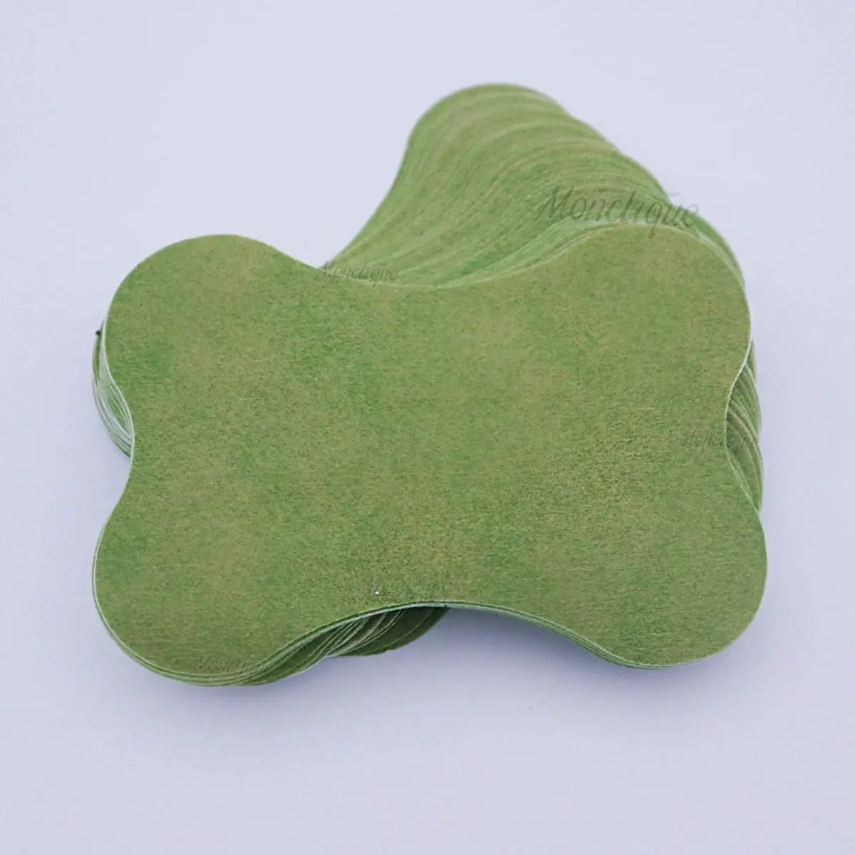 Lumbar spine self-heating patches, green clover-shaped pads stacked together