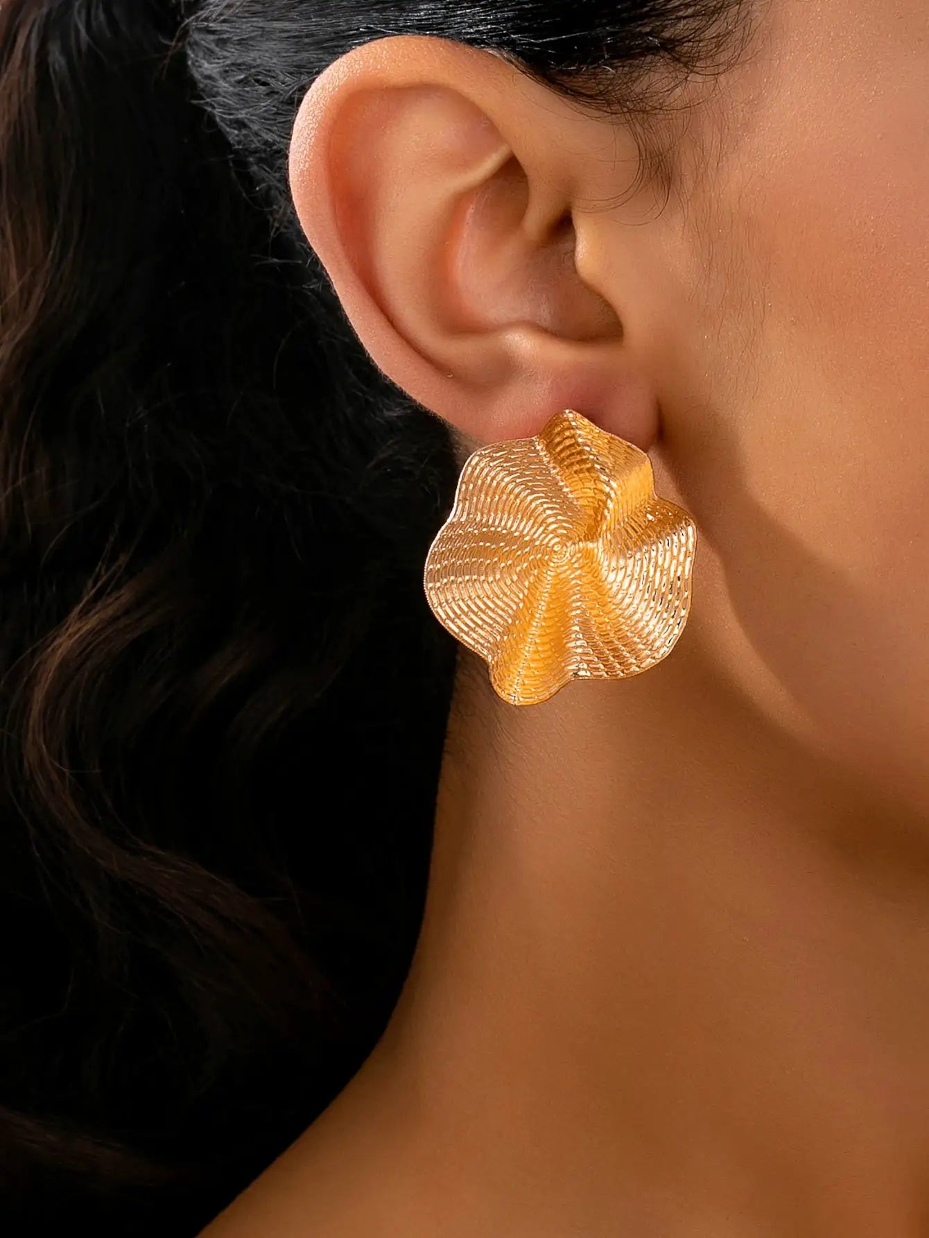 Pair of gold-tone irregular round flower-shaped metal stud earrings by Simples Market