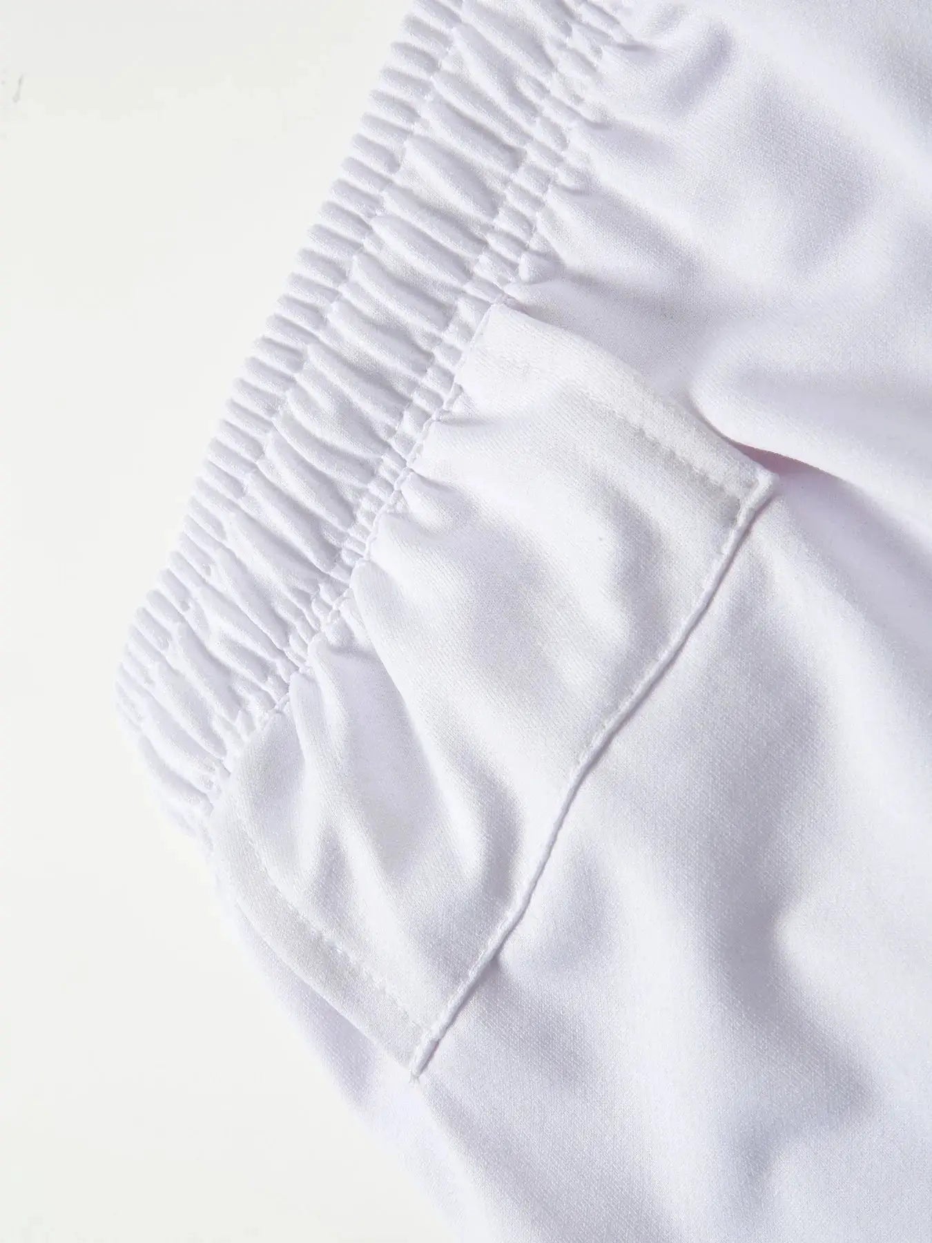 Men's white workout shorts with elastic waistband and visible stitching