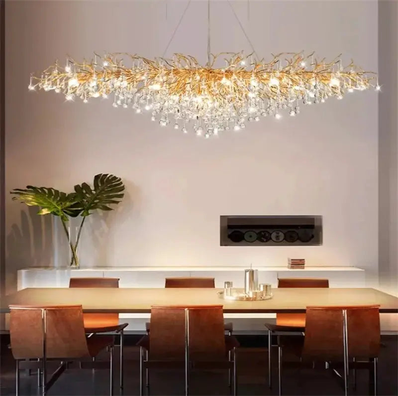 Royal Nordic luxury crystal chandelier in gold chrome with water-drop pendants over a dining table in a modern villa.