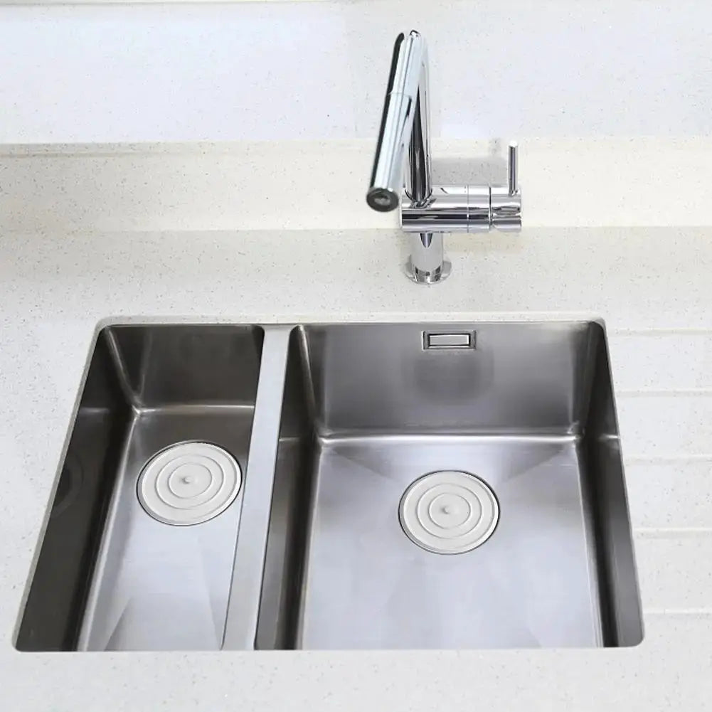 Double-basin stainless steel sink with a chrome faucet and round drain covers