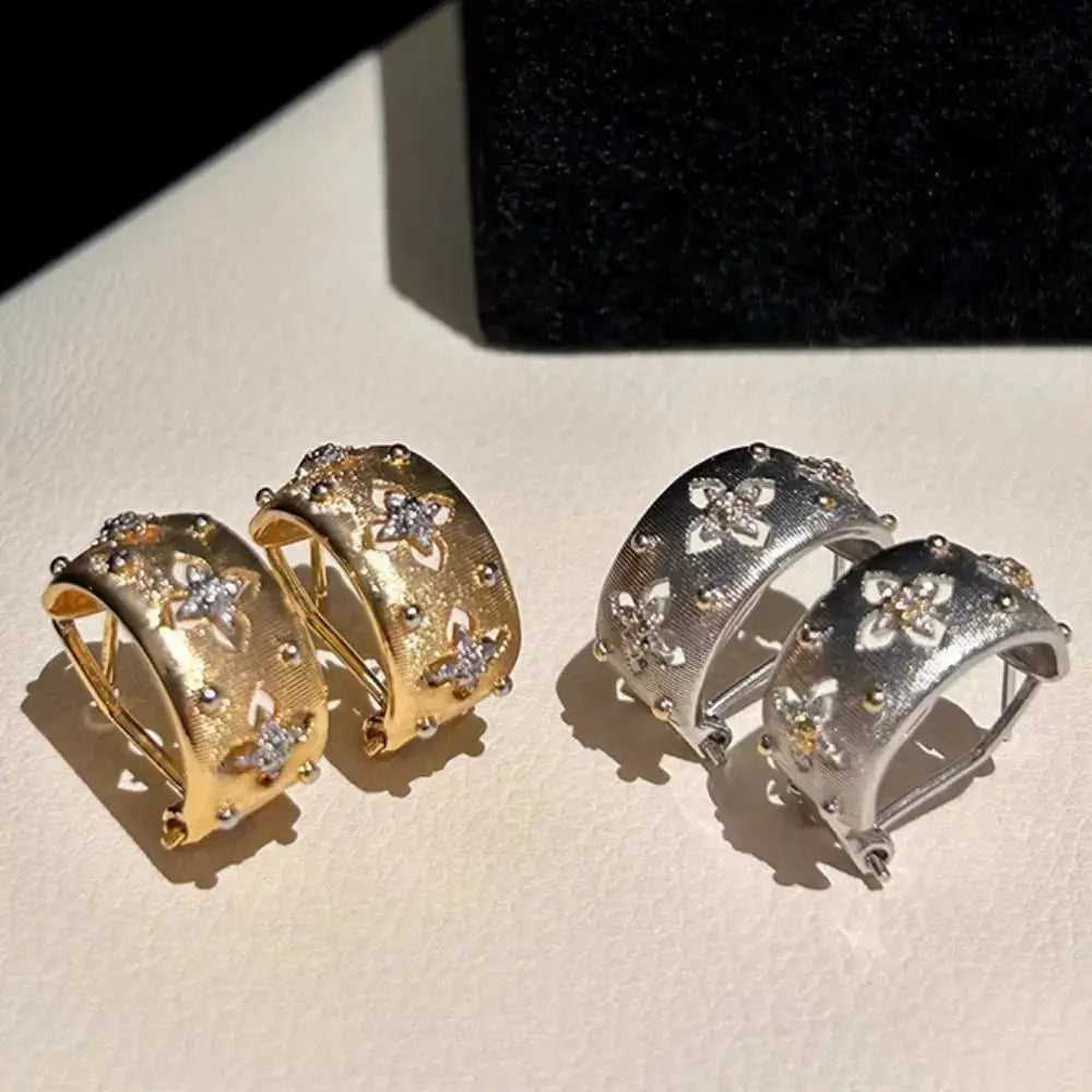 Hollow flower hoop earrings with zircon inlays; gold-tone and silver-tone finishes, two pairs visible.