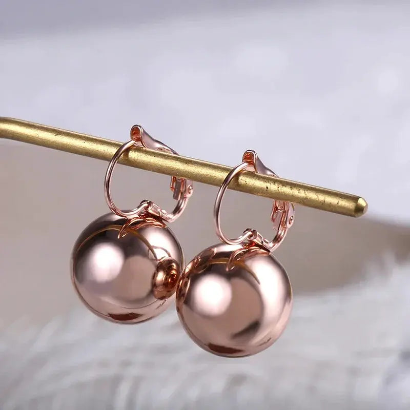Rose gold drop earrings pair with smooth ball pendants and hoop clasps for women