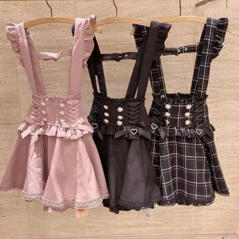 Three Gothic Lolita ribbon short suspender skirts in pink, black solid, and black plaid with lace trim and heart charms