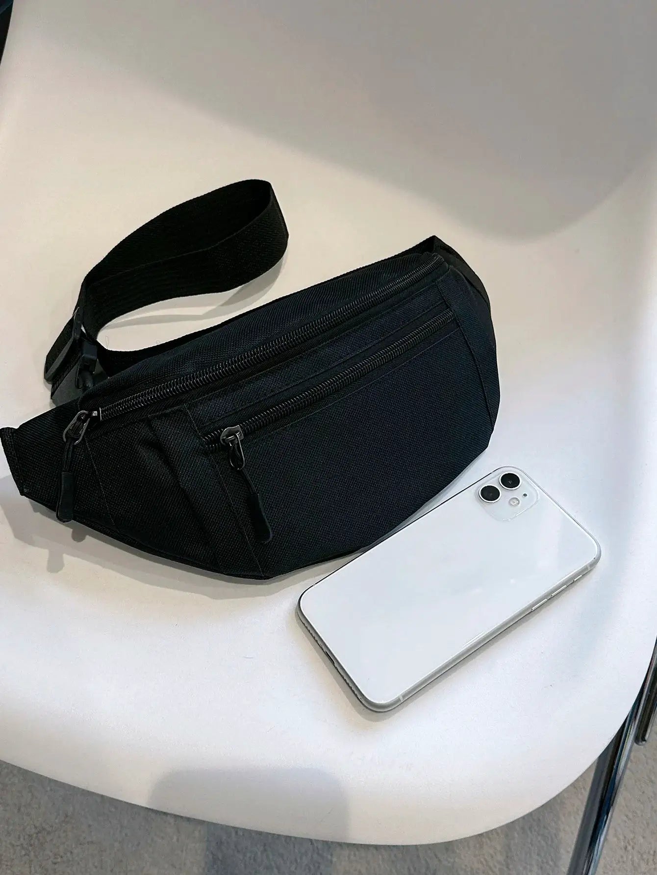 Fanny pack waist bag in black nylon with dual zipper compartments and adjustable strap.