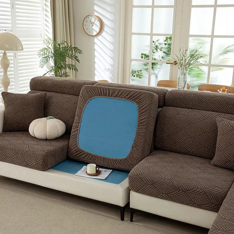 Thick plush sofa cover set with elastic edges on a brown patterned sectional sofa; blue cushion insert visible.