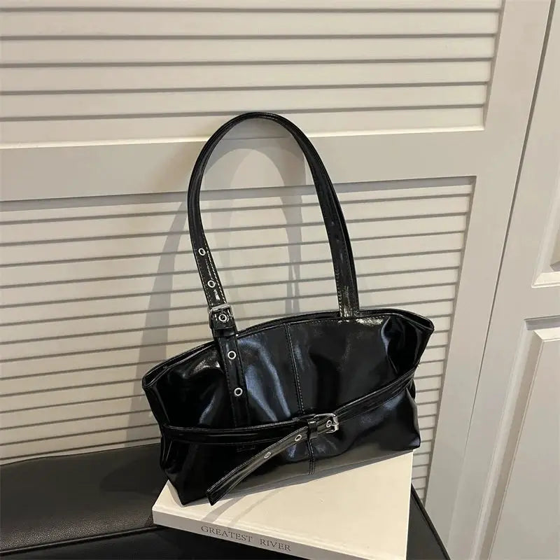 Belt-buckle handbag by Simples Market, black soft-leather with two handles for shoulder/underarm wear.