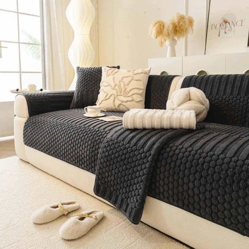 Thick quilted fleece sofa cover in charcoal geometric jacquard with anti-slip grip on living room couch.