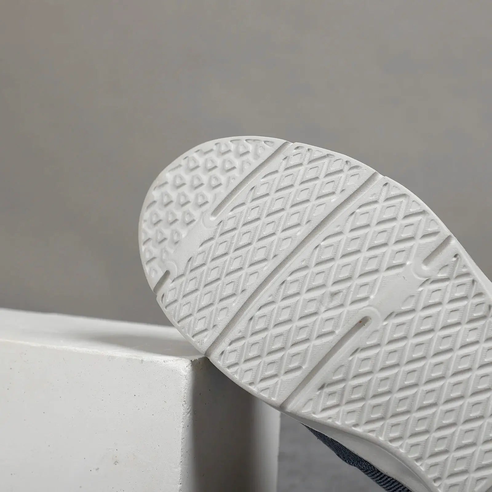 Men's canvas sneakers with white textured rubber sole and diamond tread pattern