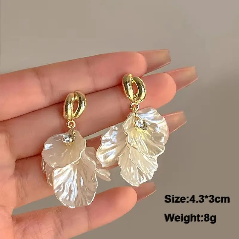 Flower drop earrings Simples Market, white translucent acrylic petals with gold-tone hoops and crystal accents pair