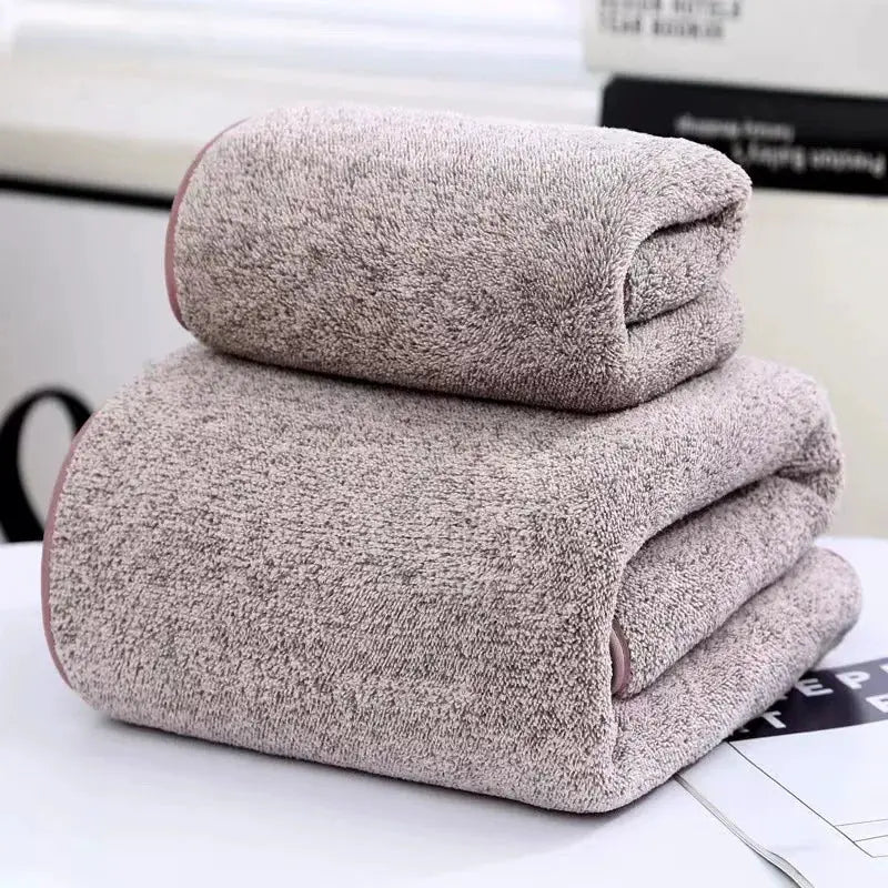 Three-piece bamboo towel set with pink trim; two beige bath towels and one beige hand towel