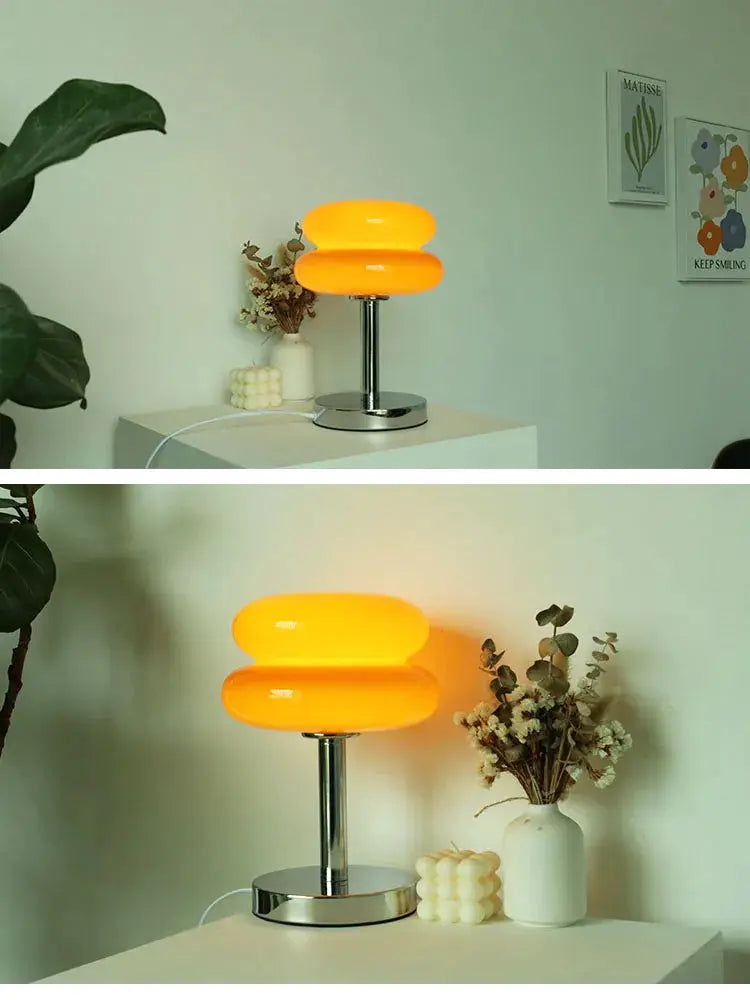 Macaron Glass Table Lamp by Simples Market, orange glass shade with chrome base on table beside vase and dried flowers