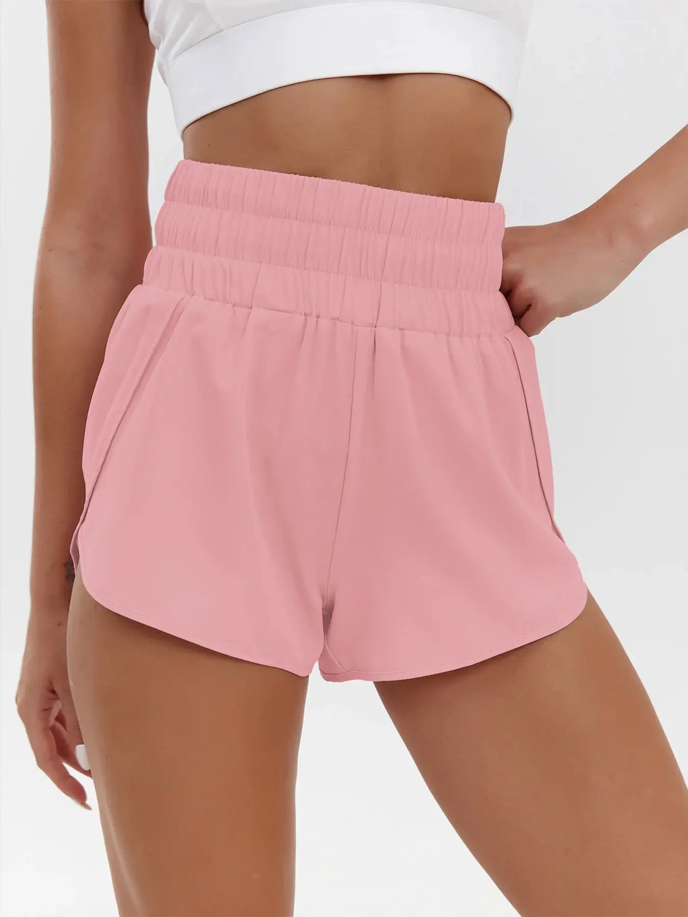 Pink high-waist elastic shorts with a loose fit and curved hems.