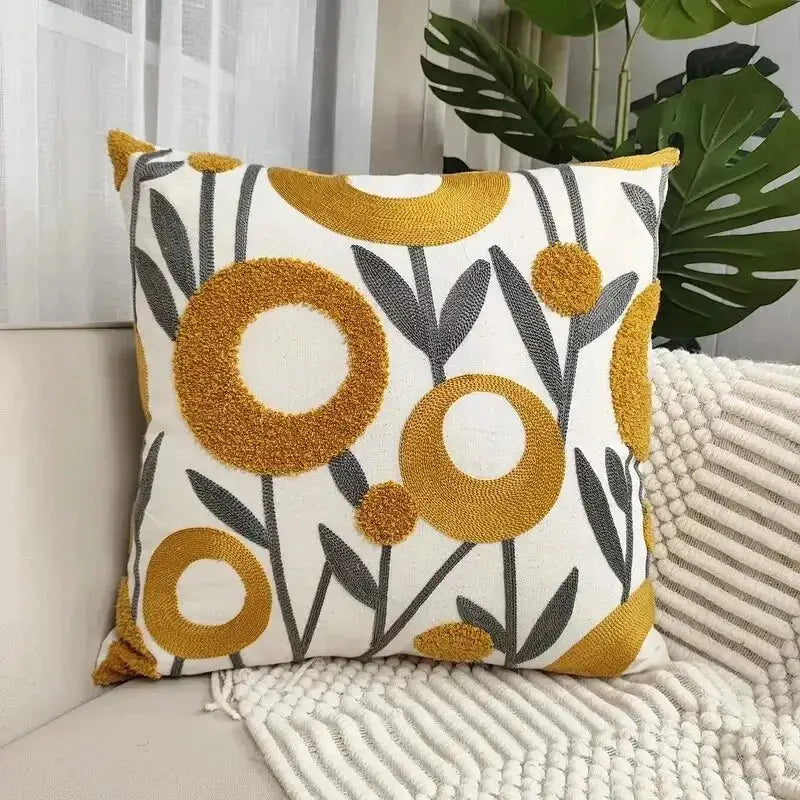 Throw pillow cover by Simples Market; boho tufted cotton cushion with white base and yellow floral rings, gray stems.