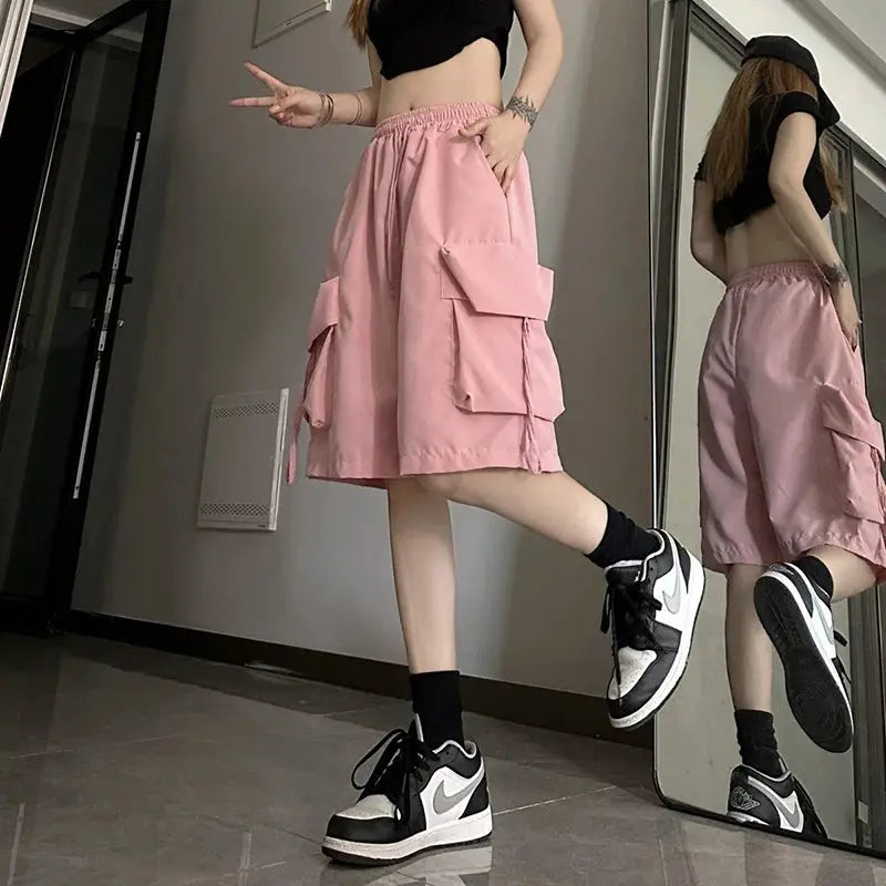 ZOKI women's pink high-waist cargo shorts with oversized pockets, streetwear style.