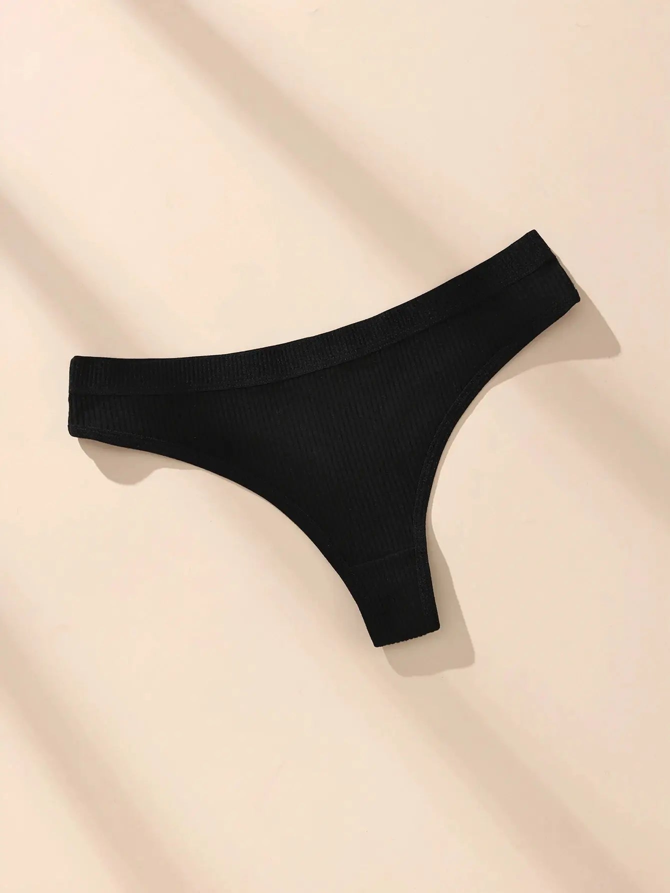 Cotton thong underwear for women, black ribbed fabric with slim waistband.