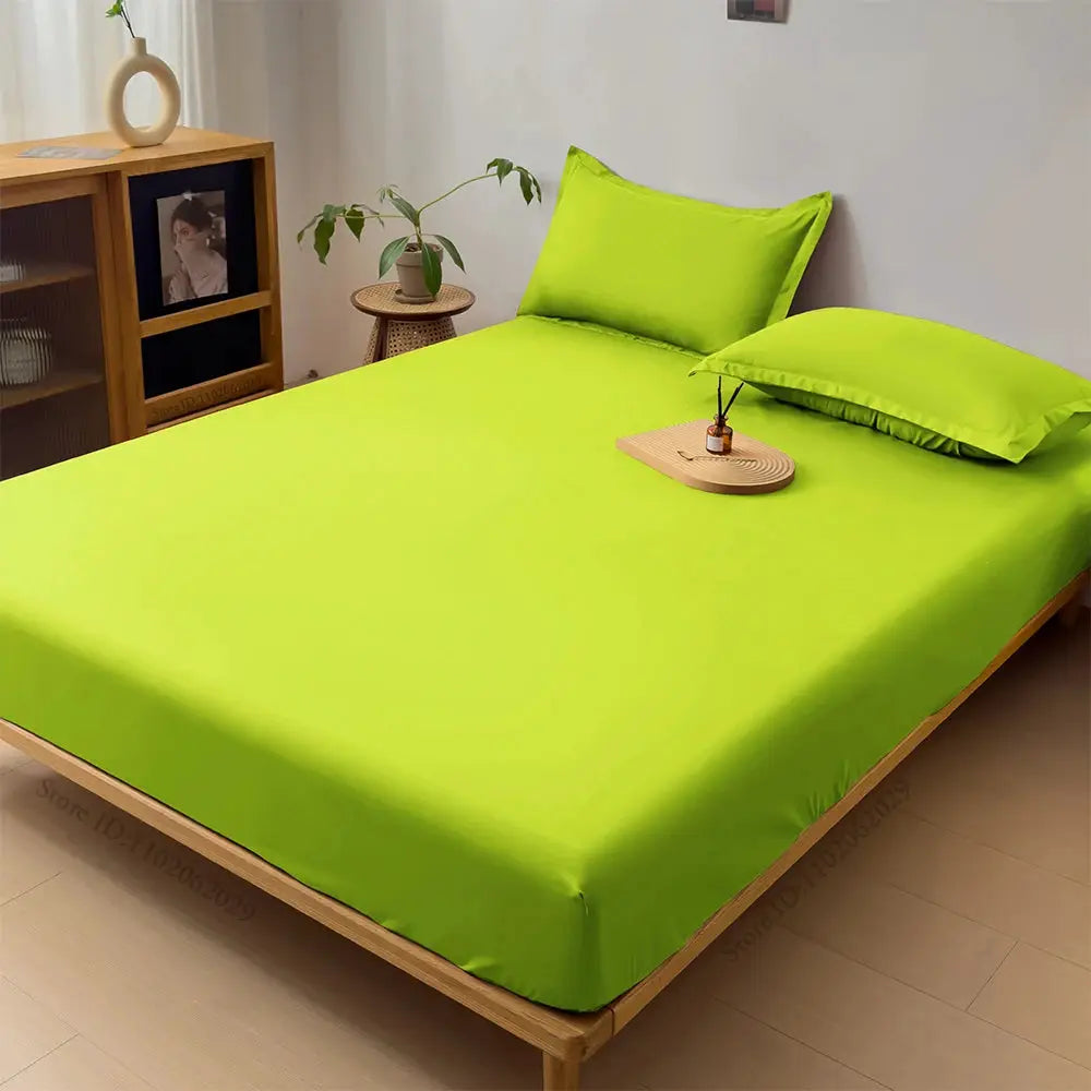 Waterproof mattress protector fitted sheet in lime green on a wooden bed with lime green pillows