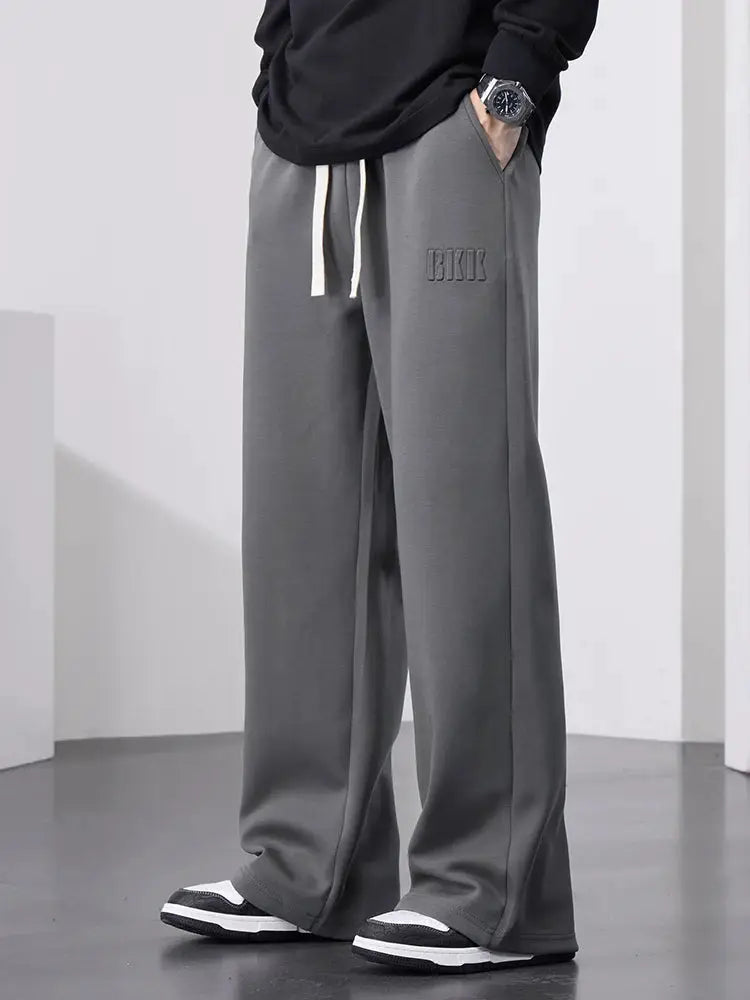 Men's grey wide-leg cotton track pants with drawstring waist.