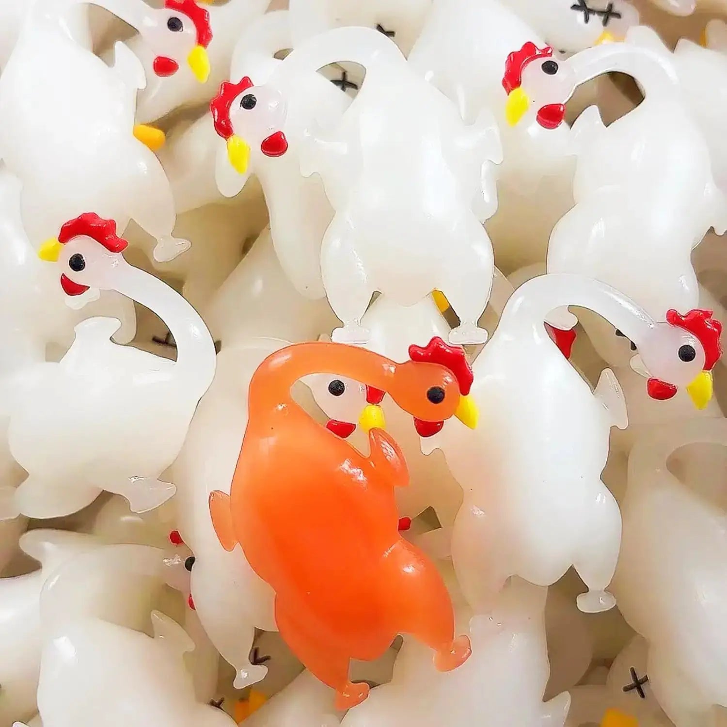 Color-changing duck pendant keychains under sunlight; white ducks with red combs and yellow beaks, orange duck visible