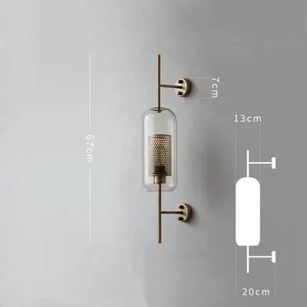 Modern glass wall lamp fixture with brass frame and perforated inner cylinder, gold finish.