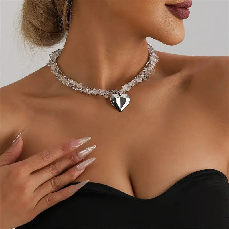 Y2K heart beaded crystal choker necklace with a silver heart pendant worn by a woman in a black strapless top