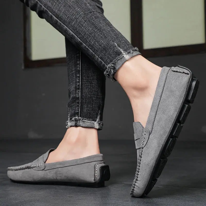 Pair of men's grey suede loafers, slip-on casual driving shoes with low-profile sole