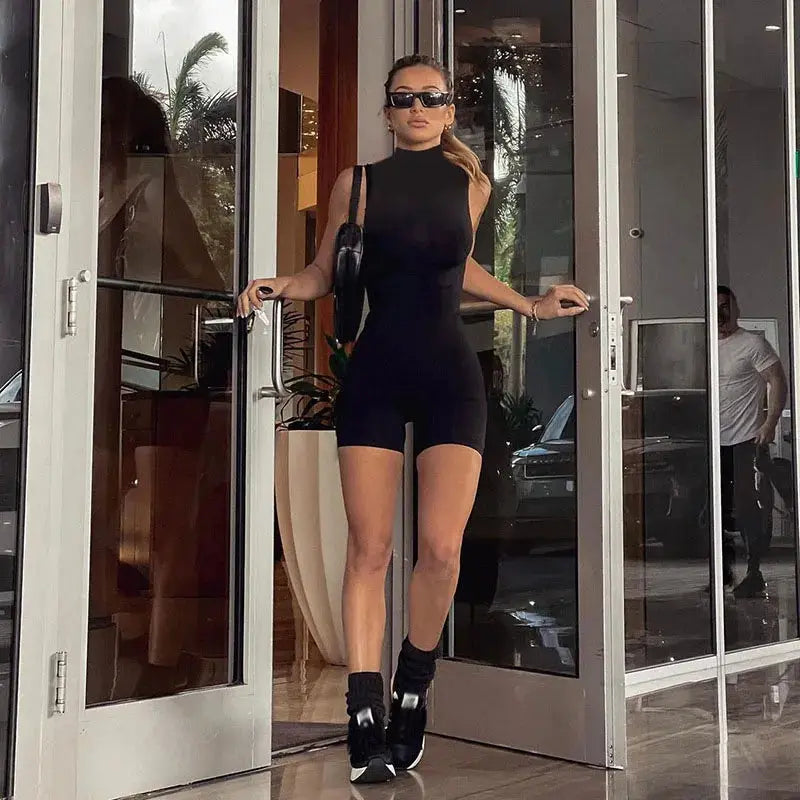 Women's black sleeveless jumpsuit romper with high-neck, shorts-length silhouette.