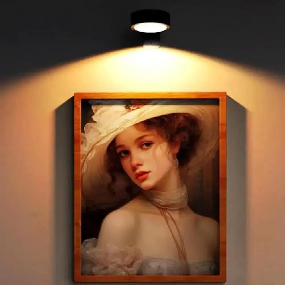 LED wall picture light mounted above a wooden-framed portrait with warm glow