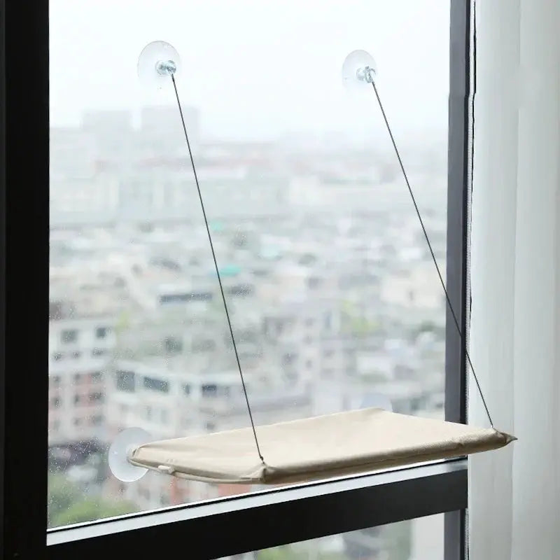Cat hammock window perch by Simples Market, beige fabric bed with two cords and suction cups