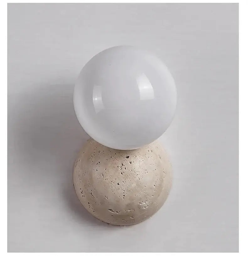LED globe wall lamp on beige stone base by Simples Market, cream-style Nordic bedroom lighting