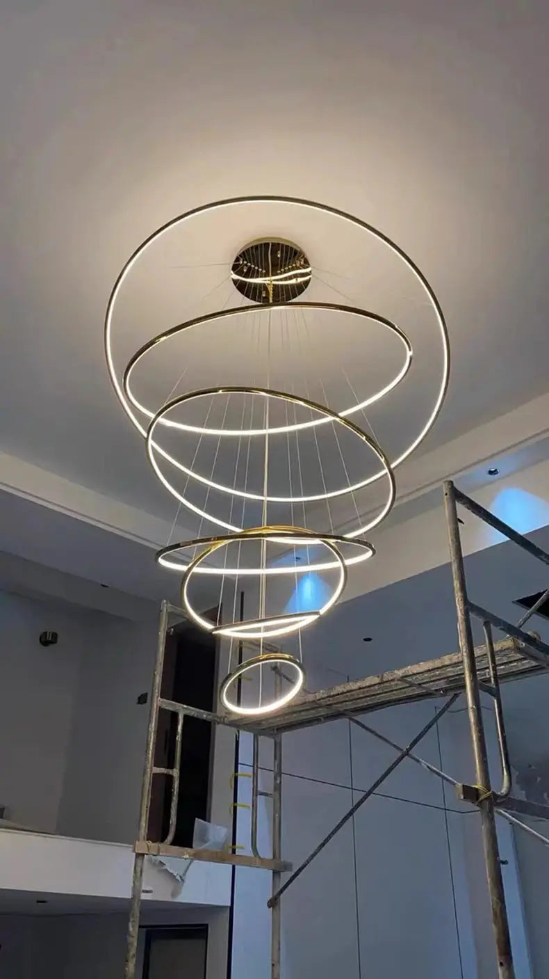Pendant light by Simples Market: LED ring chandelier with six gold-tone concentric rings.