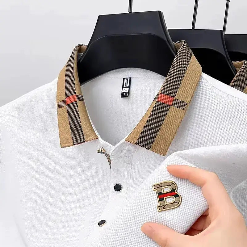 Two white polo shirts with plaid collars and a gold B logo on the chest.