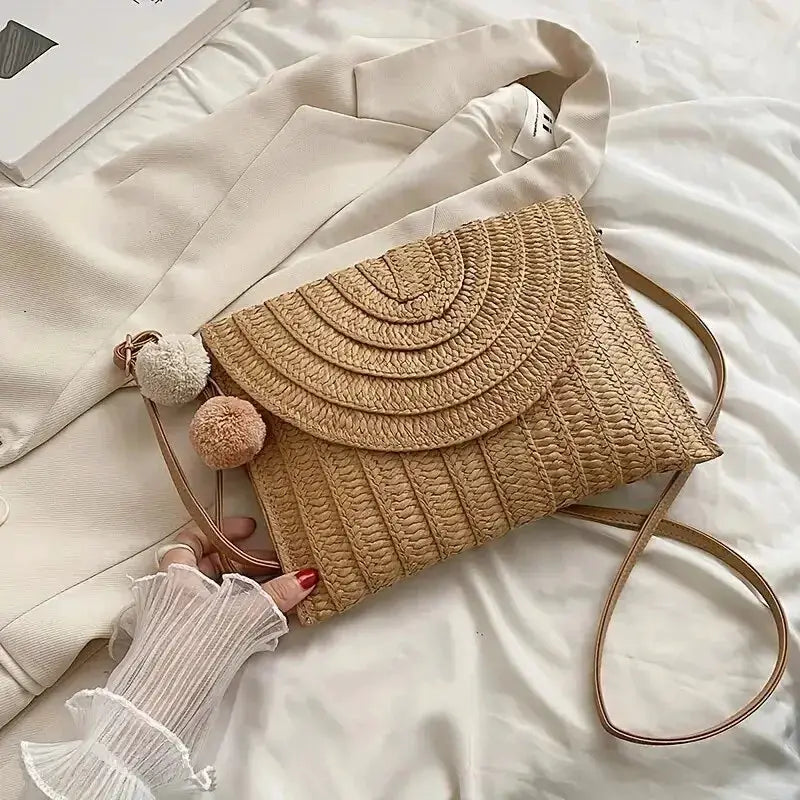 Handmade straw shoulder crossbody bag by Simples Market, natural beige woven envelope flap with pom-pom tassels