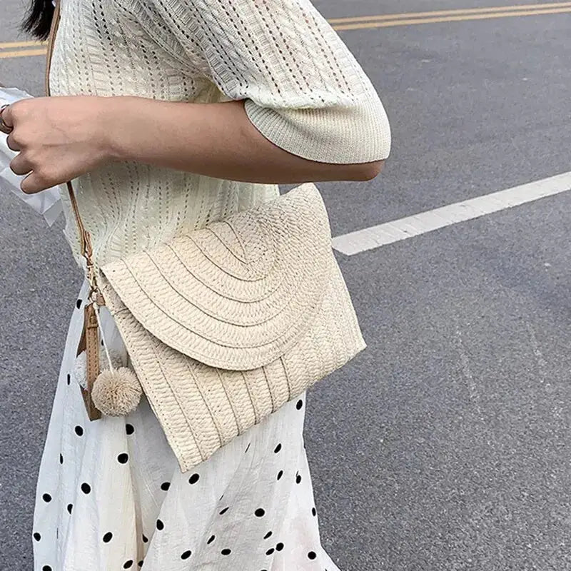 Handmade straw crossbody bag in beige with envelope flap and pom-pom charm