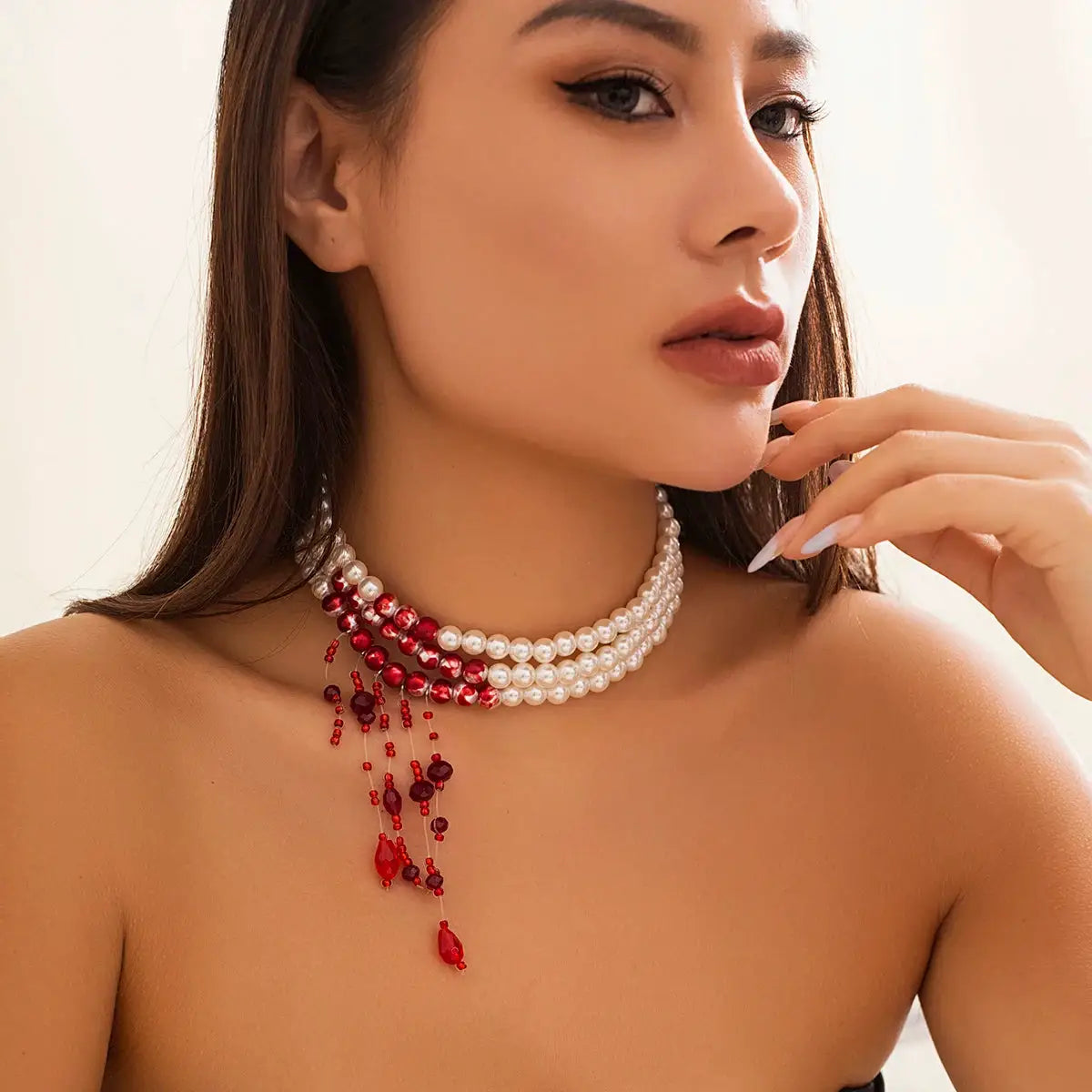 Multilayer pearl tassel necklace for women; three white faux pearl strands with red crystal bead tassel fringe.