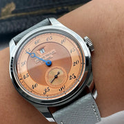 Pierre Paulin Jumping Hour watch with salmon dial, blue hands, date window, stainless steel case, gray leather strap