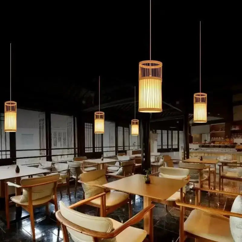 Chinese-style bamboo lantern chandeliers in a Zen teahouse restaurant with warm amber lighting over wooden tables