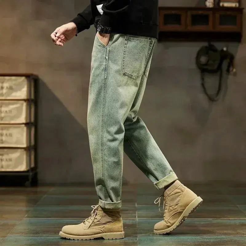 Men's denim cargo pants in light olive green, loose-fit Harajuku-style with rolled cuffs.