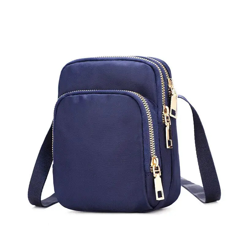 Women’s navy blue waterproof crossbody bag with double gold zippers and adjustable strap.