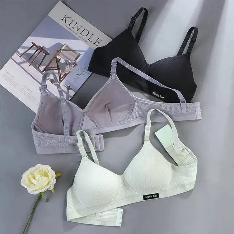 Three cotton wireless AB-cup bras for women in black, light gray, and white with adjustable straps.