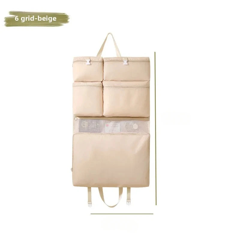 Hanging travel storage bag; beige, foldable organizer with multiple pockets for clothes and underwear.